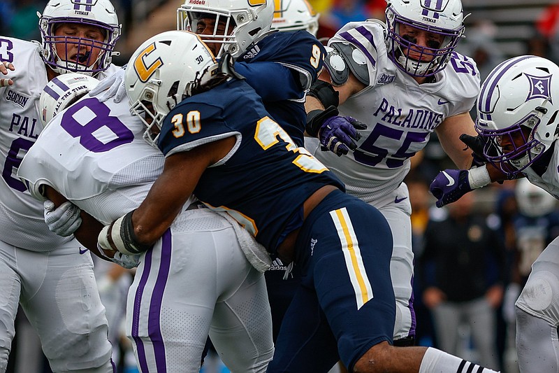 Staff photo by Troy Stolt / Chattanooga Mocs linebacker Jay Person (30) tackles Furman Paladins running back Dominic Roberto (8) during the football game between UTC and Furman at Finley Stadium on Saturday, Oct. 30, 2021 in Chattanooga, Tenn.