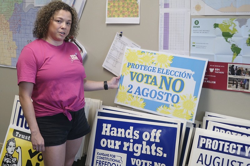 Jessica Porter, communications chair for the Shawnee County, Kansas, Democratic Party, discusses a sign in Spanish urging voters to oppose a proposed amendment to the Kansas Constitution to allow legislators to further restrict or ban abortion, Friday, July 15, 2022, in Topeka, Kansas. The proposed amendment is a response to a 2019 Kansas Supreme Court decision protecting abortion rights. (AP Photo/John Hanna)