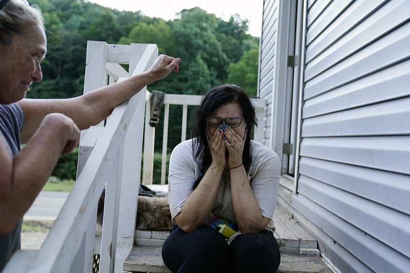 Kirsten Gomez, right, cries to her family member Kathy Hall, left, after what she calls a quiet moment to reflect on what her family has gone through in the aftermath of massive flooding, Tuesday, Aug. 2, 2022, in Hindman, Ky. (AP Photo/Brynn Anderson)