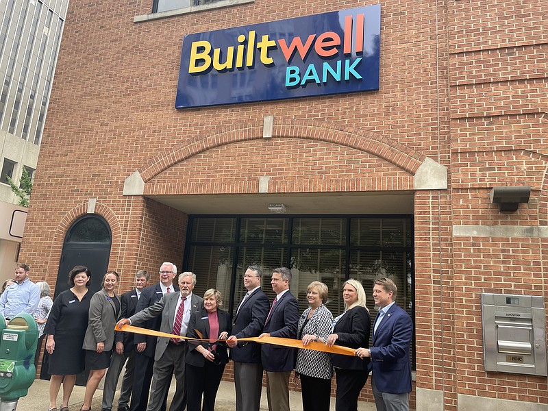 Photo by Dave Flessner / Builtwell Bank leaders, including President Patti Steele who is holding the scissors, cut the ribbon Thursday for the rebranded bank at its downtown Chattanooga headquarters on Broad Street. The former First Volunteer Bank was renamed Builtwell Bank this week after an employee contest came up with the new name as the bank expands beyond the Volunteer State. Photo was taken August 4, 2022.