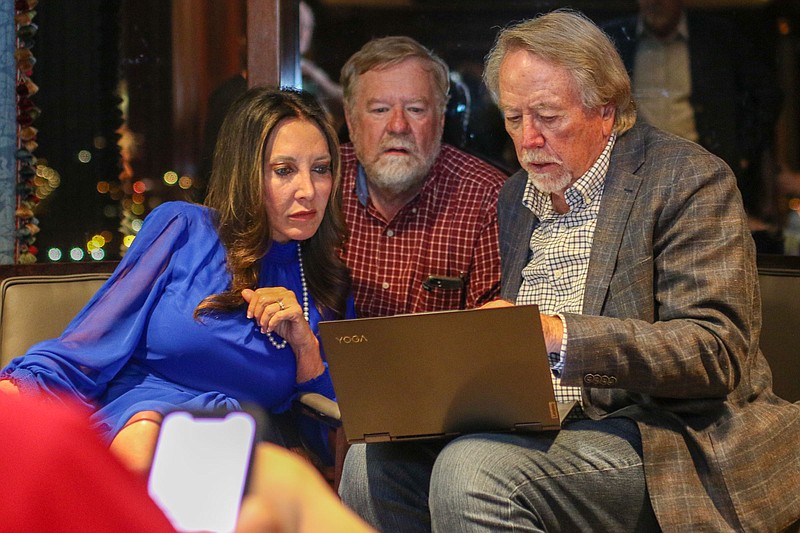 Sabrena Smedley, left, looks with Jay Wilson and Tom Ingram at the primary mayor's race numbers after the election ended on May 3.