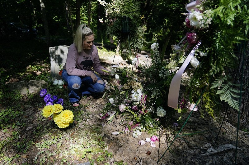 Angel Campbell, 37, visits her grandmother's, Nellie Mae Howard, 82, "Mammaw" grave on Thursday, Aug. 4, 2022, in Chavies, Ky. Howard died in massive flooding. (AP Photo/Brynn Anderson)