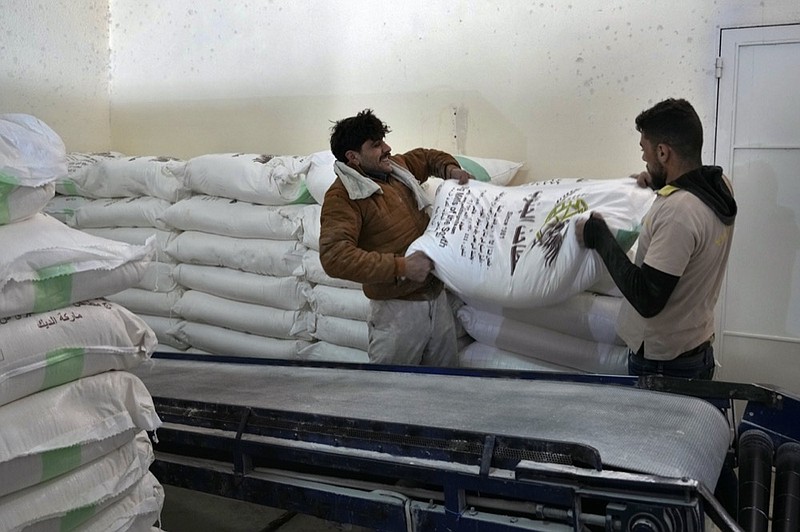 Workers load bags of flour into a truck at the Big Mills factory in the southern town of Sebline, south of Beirut, Lebanon, March 15, 2022. (AP Photo/Bilal Hussein, File)