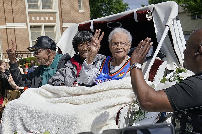 FILE - In this May 28, 2021 file photo, Tulsa Race Massacre survivors, from left, Hughes Van Ellis Sr., Lessie Benningfield Randle, and Viola Fletcher, wave and high-five supporters from a horse-drawn carriage before a march in Tulsa, Okla. (AP Photo/Sue Ogrocki File)



