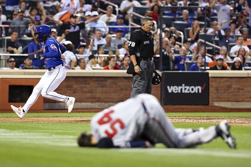AP photo by Jessie Alcheh / Francisco Lindor scores for the New York Mets on a throwing error by Atlanta Braves shortstop Dansby Swanson as pitcher Max Fried (54) lies on the ground during the third inning of the second game of a baseball doubleheader Saturday in New York.