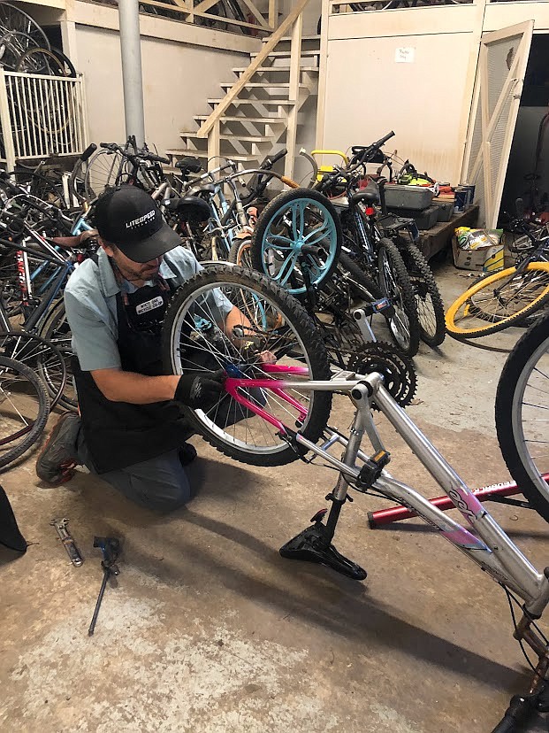 Contributed Photo by White Oak Bicycle Cooperative / Blake Pierce, executive director of White Oak Bicycle Cooperative, works on donated bicycles to be distributed to residents in need.