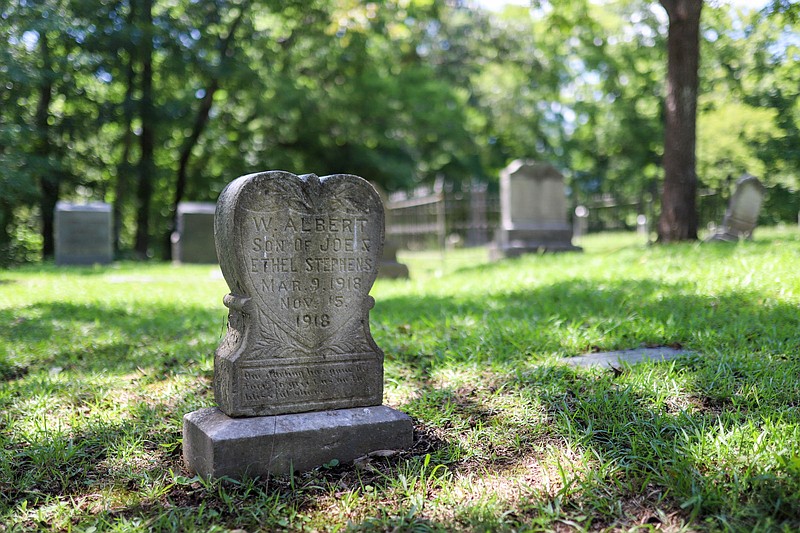 Staff photo by Olivia Ross  / A headstone sits in the Red Bank Cemetery on August 6, 2022. Located within a neighborhood, the Red Bank Cemetery is one of two cemeteries owned by the city that has plans for sustainable maintenance. 