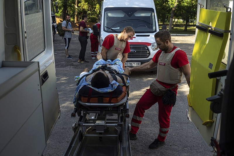Volunteers of the Ukrainian Red Cross emergency transport a wounded man from one to another hospital in Mykolaiv, Ukraine, Tuesday, Aug. 9, 2022. (AP Photo/Evgeniy Maloletka)


