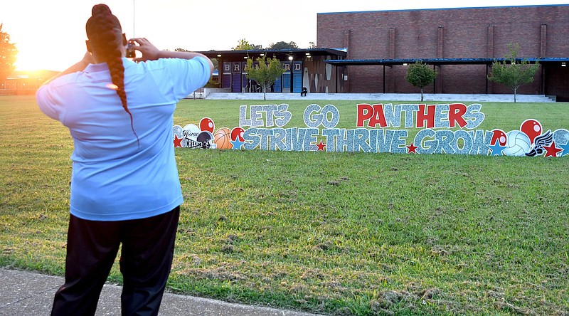 Staff Photo by Robin Rudd / As the sun rises behind Brainerd High School Executive Principal Dr. Crystal Sorrells takes a photo of the inspirational sign, out front, on the first day of school. Elected officials, law enforcement officers, community leaders and alumni gathered at Brainerd High School to welcome back students on the first day of school, on August 10, 2022.