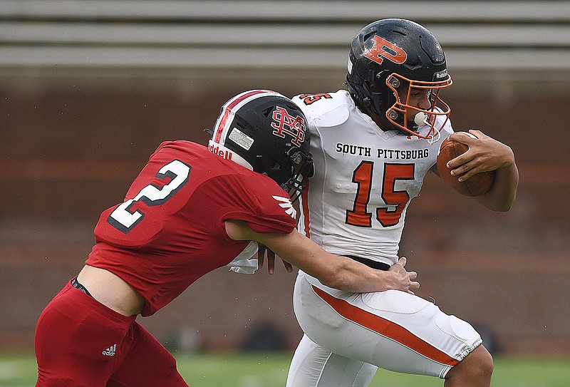 Staff photo by Matt Hamilton / South Pittsburg quarterback Kamden Wellington (15) breaks away from Signal Mountain's Forrest Payne as he attempts to make a tackle during the first night of the Best of Preps football jamboree Thursday at Finley Stadium.