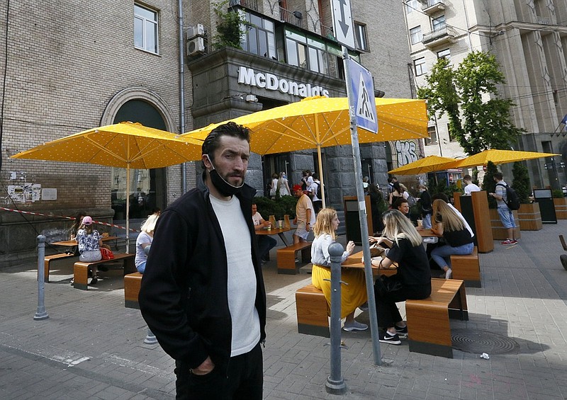 FILE - People, some of them still in masks to protect against coronavirus, enjoy outdoor McDonald's meal in downtown Kyiv, Ukraine, on June 9, 2020. McDonald's announced Thursday, Aug. 10, 2022, that the company will start reopening restaurants in Ukraine in the coming months, a symbol of the war-torn country's return to some sense of normalcy and a show of support after the American fast-food chain pulled out of Russia. (AP Photo/Efrem Lukatsky, File)