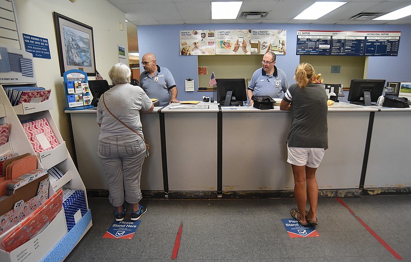 Staff photo by Matt Hamilton / Postal employees help customers in the lobby area at the Signal Mountain Post Office on Thursday, Aug. 11, 2022.