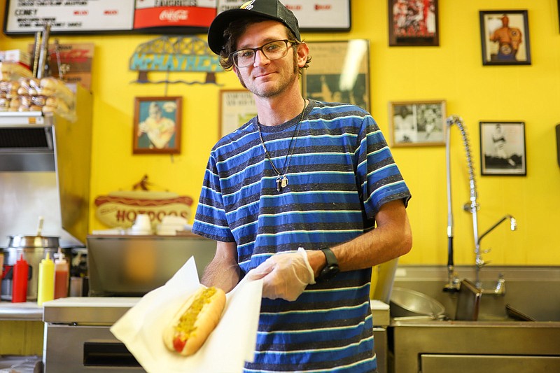 Staff photo by Olivia Ross  / Josh Hyde poses with a hot dog on August 15, 2022 at Miss Griffin's Foot Long Hot Dogs. Miss Griffin's, who has served Chattanooga foot-long hot dogs since 1939, will be relocated due to the current building being purchased. 