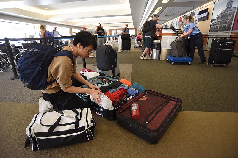 Staff Photo by Matt Hamilton / Marc Guarino reorganizes his bags to get both under 50 pounds before flying to Sacramento, Calif., on July 1 at the Chattanooga Airport.